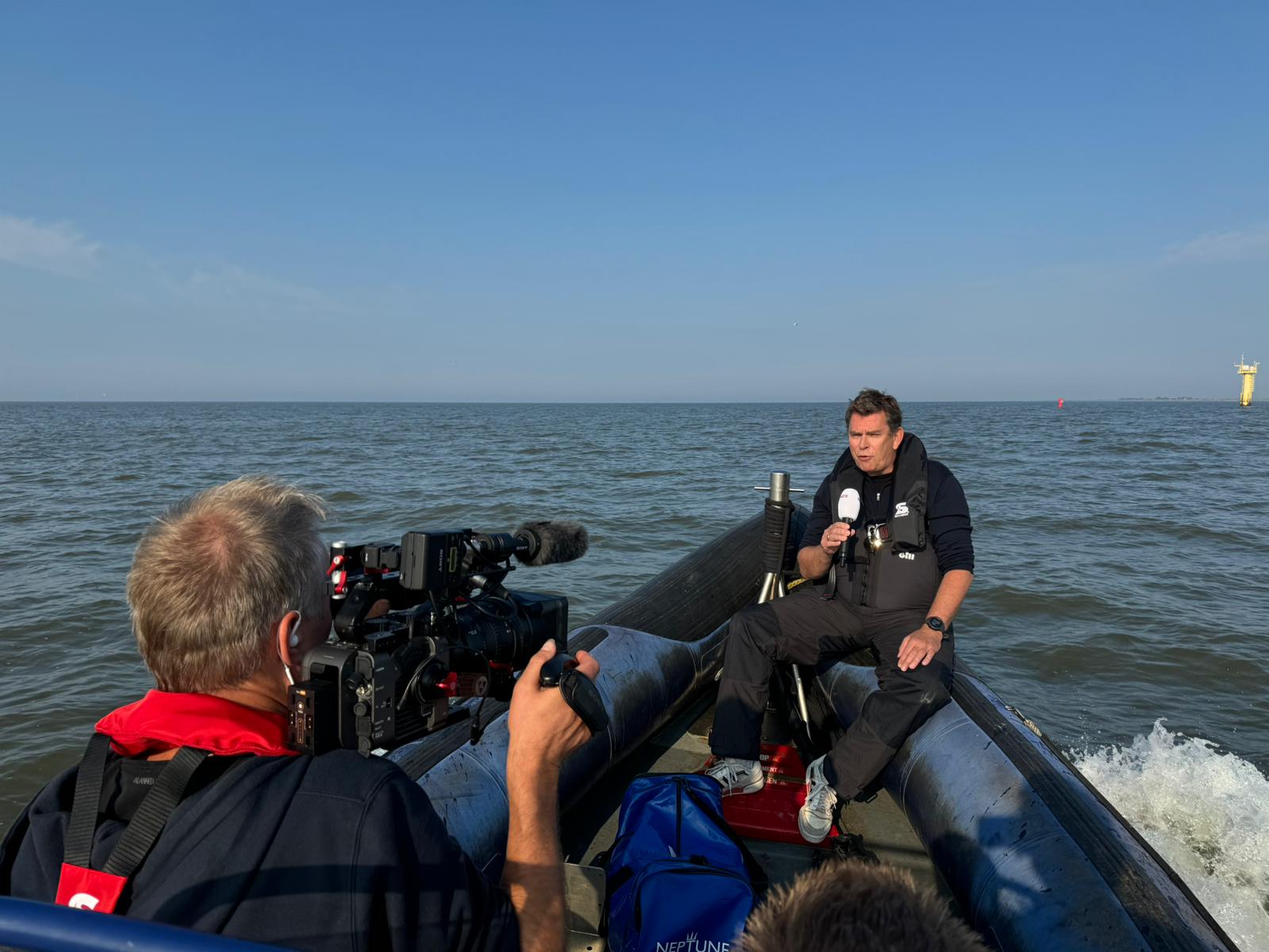 Filmteam i gummibåt på havet filmar en intervju