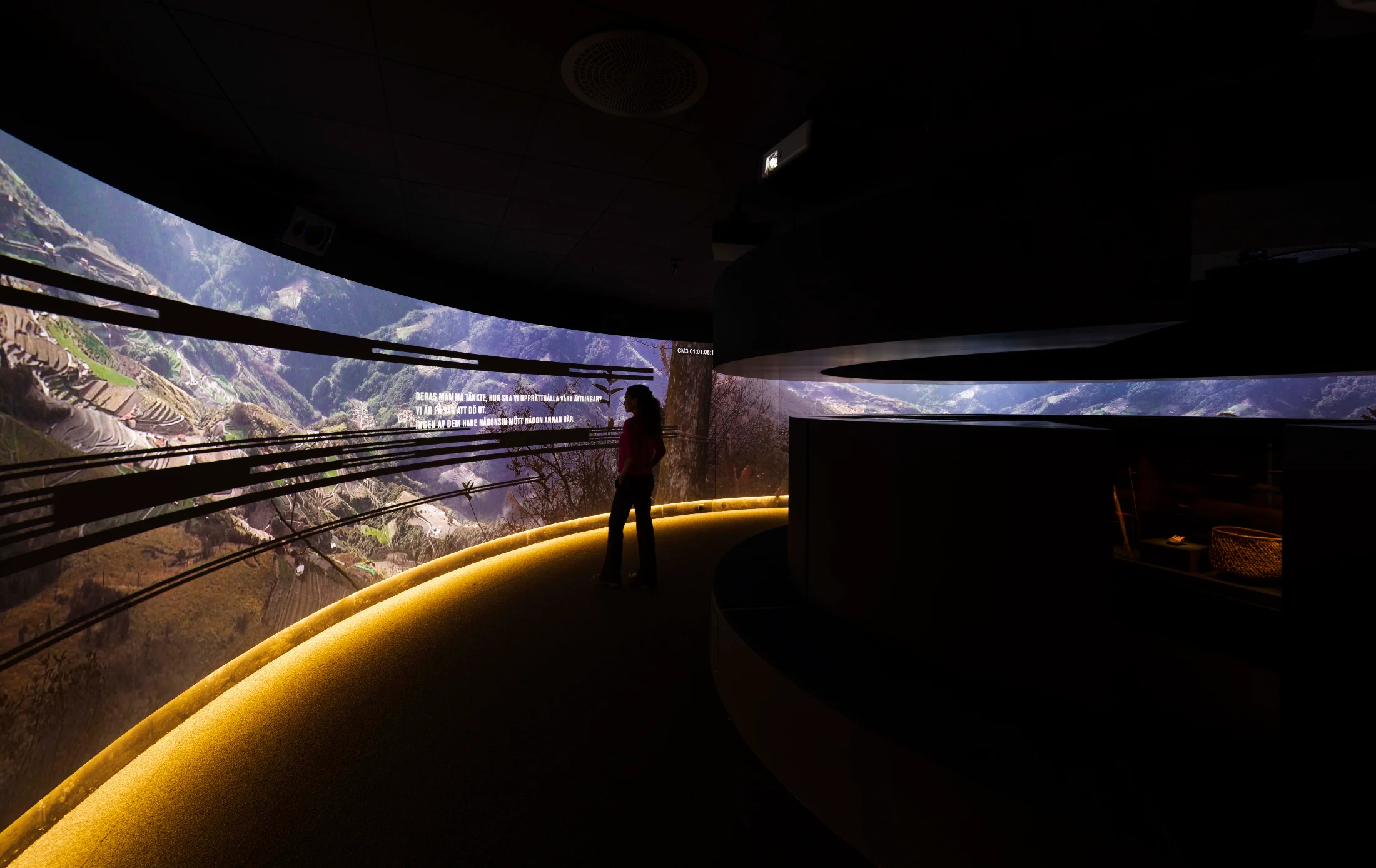 Besökare framför den böjda panoramaprojektionen i utställningen We Are Seediq