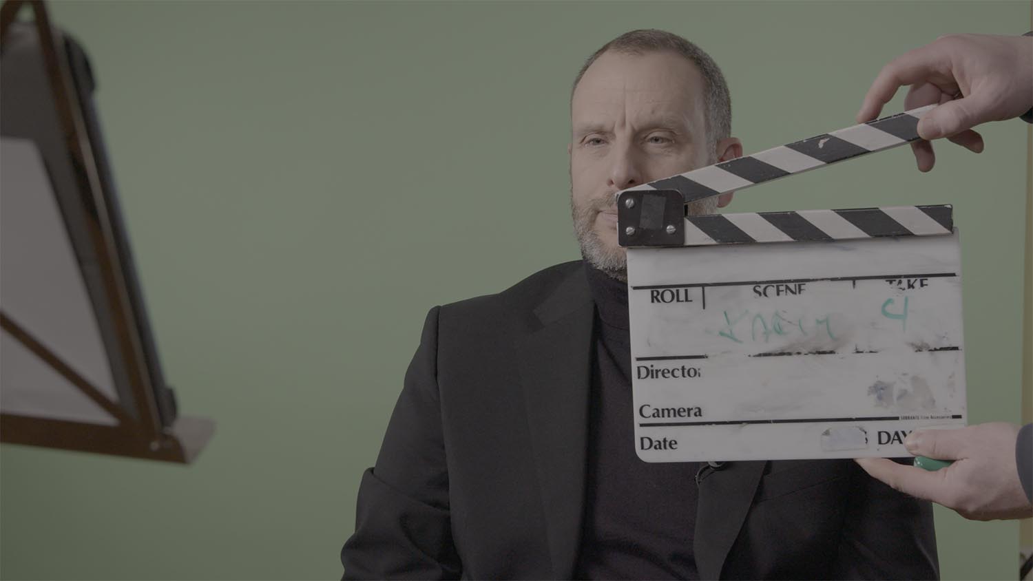 Filminspelning av en intervju med en filmklappa framför en man i kavaj
