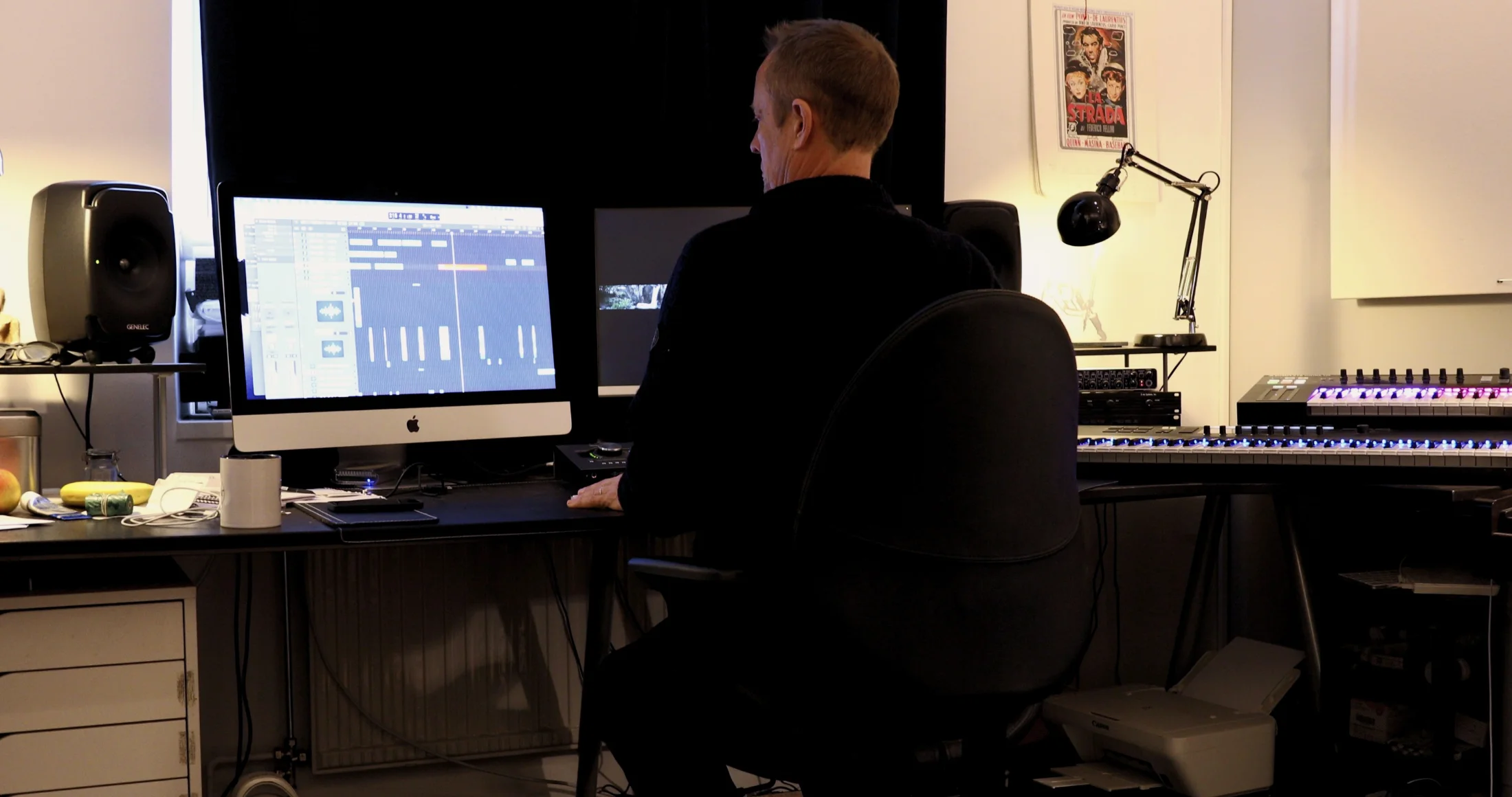 Person arbetar vid dator och syntar i en ljudstudio